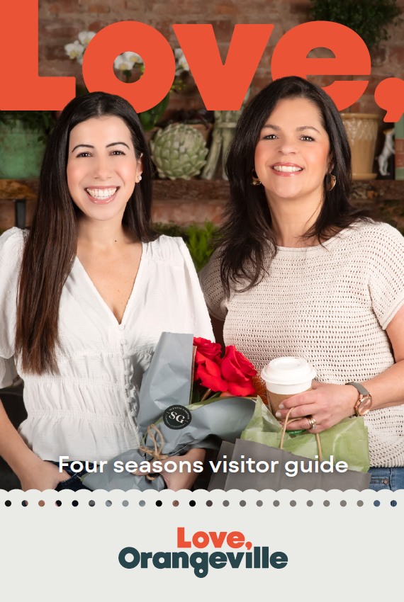 Cover of Orangeville Visitor Guide. There are two women smiling and holding flowers and coffee.